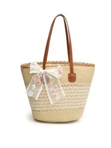 Handwoven straw tote bag with brown leather handles and pink floral embroidery