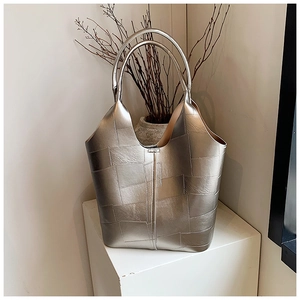Détail du cabas métallisé argenté avec texture en cuir matelassé sur présentoir