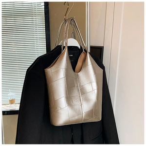 Gros plan du sac cabas doré champagne avec patchwork géométrique et finition métallique