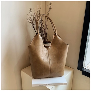 Détail du sac fourre-tout kaki à patchwork géométrique sur présentoir minimaliste
