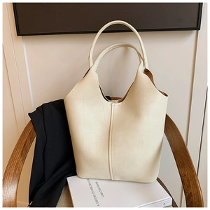 Gros plan d'un grand sac cabas crème avec texture en cuir gaufré géométrique