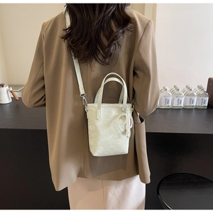 Back view of model wearing a mint green bucket bag with pearl heart charm and strap