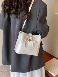 Elegante borsa a secchiello crema motivo coccodrillo con fiocco di perle e tracolla