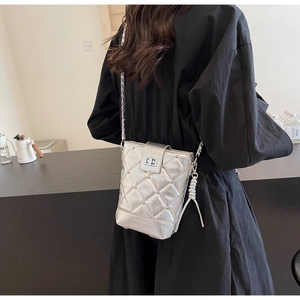 Nahaufnahme der silbernen Stepptasche mit Metallnieten und poliertem Drehverschluss