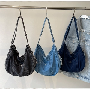 Hobo denim tote bags in black and blue hanging on display with frayed edge detail