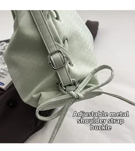 Détail de la boucle en métal argenté et du cordon de serrage sur le sac vert menthe