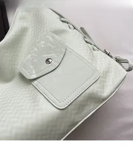 Gros plan sur le sac fourre-tout vert menthe avec texture matelassée et bouton