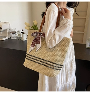 Grand sac cabas en paille avec anses en cuir marron et foulard en soie rouge sur modèle