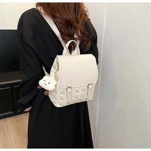 Vue arrière d'un sac à dos en cuir beige avec motifs d'ours et pendentif nuage