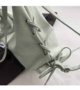 Détail du sac fourre-tout vert menthe avec lacets croisés, cordon et œillets en argent