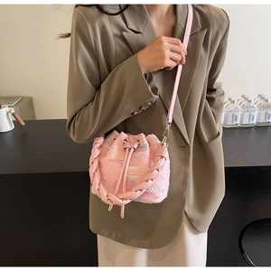 Pink drawstring bucket bag in leather and jacquard fabric shown as a crossbody view