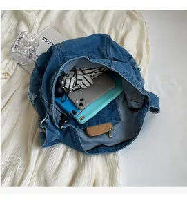 Spacious interior of distressed denim tote bag showing capacity for tablet and phone