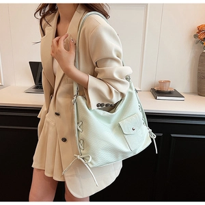 Détail du sac fourre-tout vert menthe avec texture tissée et nœud décoratif latéral