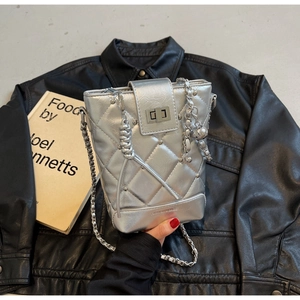 Nahaufnahme der silbernen Stepptasche mit Metallkette und modischer Textprägung
