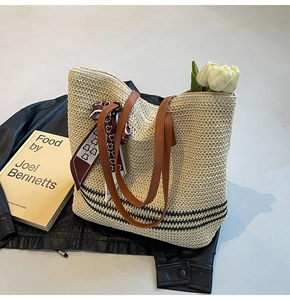 Détail du sac cabas en paille tissée avec anses en cuir, foulard et décor tulipe