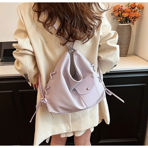Détail d'un sac à dos en cuir lilas avec cordon de serrage et boucles argentées sur modèle