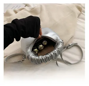 Detail view of mini silver dumpling bag showing internal capacity for small items