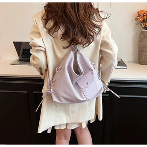 Détail d'un sac cabas tissé lavande avec nœuds coulissants porté par un mannequin au bureau