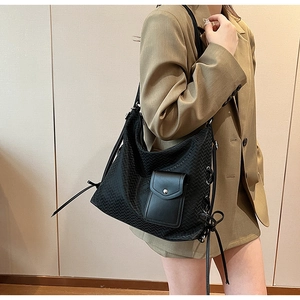 Détail du sac cabas en cuir tressé noir avec nœud latéral et poche à rabat aimanté