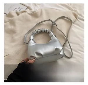 Close-up of silver metallic leather dumpling bag with ruched handle and slim shoulder strap