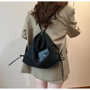 Détail de la texture tissée et de la poche à rabat en cuir du sac noir multifonctionnel