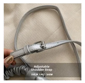 Detail of adjustable metal buckle shoulder strap on silver matte PU pleated bag
