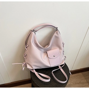 Détail du sac cabas rose tressé avec lacets latéraux et petite poche frontale