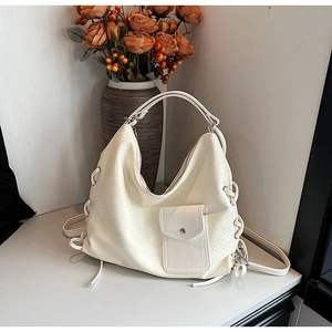 Gros plan du sac cabas tissé crème avec poche avant et détails de texture élégants