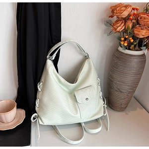 Détail de la texture tissée vert menthe sur un sac cabas avec poche à bouton argenté