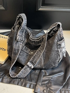 Black washed denim crescent bag with adjustable strap and distressed details