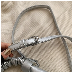 Detail of silver pleated cloud bag featuring adjustable strap and metallic hardware