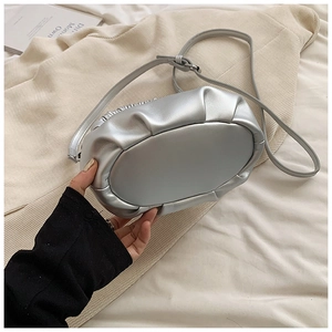 Macro view of silver pleated dumpling bag showing metallic leather texture and bottom base