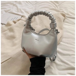 Detail of silver metallic dumpling bag with ruched handle and brand logo