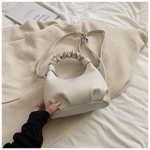 Detail of light beige pleated cloud bag with soft PU leather texture and silver hardware
