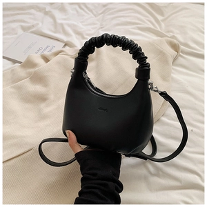 Detail of black matte leather dumpling bag with ruched handle and shoulder strap