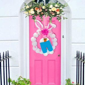 Easter bunny wreath with pom-poms, pink bow, rabbit ears and legs for door decoration