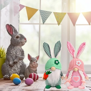 Close-up of Easter gnomes with rabbit ears and carrots in a sunny festive setting