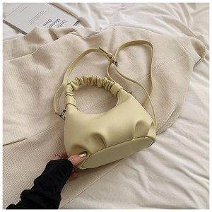 Close-up of cream pleated dumpling bag with scrunchie handle and adjustable strap