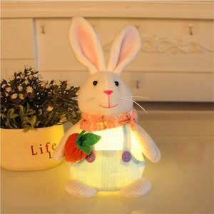 Gros plan du lapin de Pâques lumineux en salopette tenant une carotte sous lumière chaude