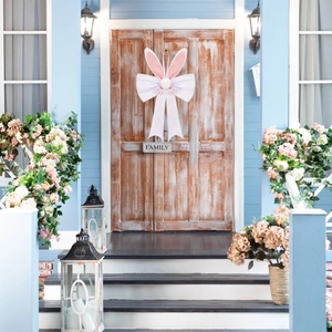 Easter rabbit ear hanging ornament with white silk bow on a wooden door decoration