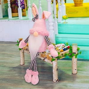 Detailed view of a pink Easter gnome plush with long checkered legs on a wooden bench