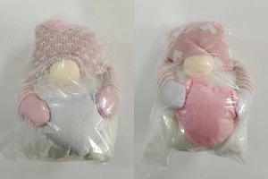 Detail of pink faceless gnomes with light-up hearts and knitted textures in packaging