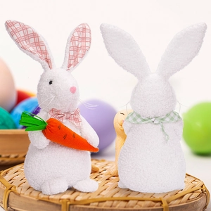 Close-up of plush Easter bunny ornaments with carrot and bowties on a woven tray