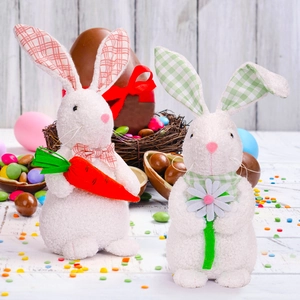 Close-up of plush Easter bunnies with plaid details and carrots on a festive table