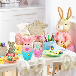 Detail of plush Easter bunnies in bee-themed pots holding flowers for holiday decor