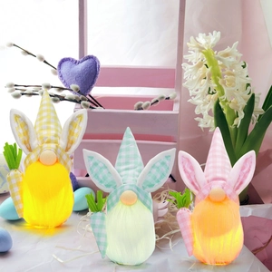 Glow-in-the-dark Easter gnomes with rabbit ears holding carrots on a floral background