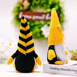 Detail view of bee gnomes with striped hats and sunflowers in a cozy home setting