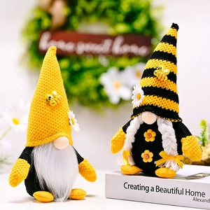 Detail of bee festival gnomes with yellow knit hats and daisies on a stack of books