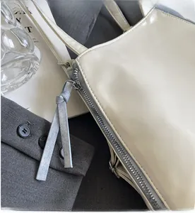 Detail of grey zipper with knotted puller on cream white minimalist tote bag