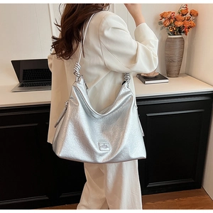 Detail of silver metallic hobo bag featuring crinkled texture and knotted strap design